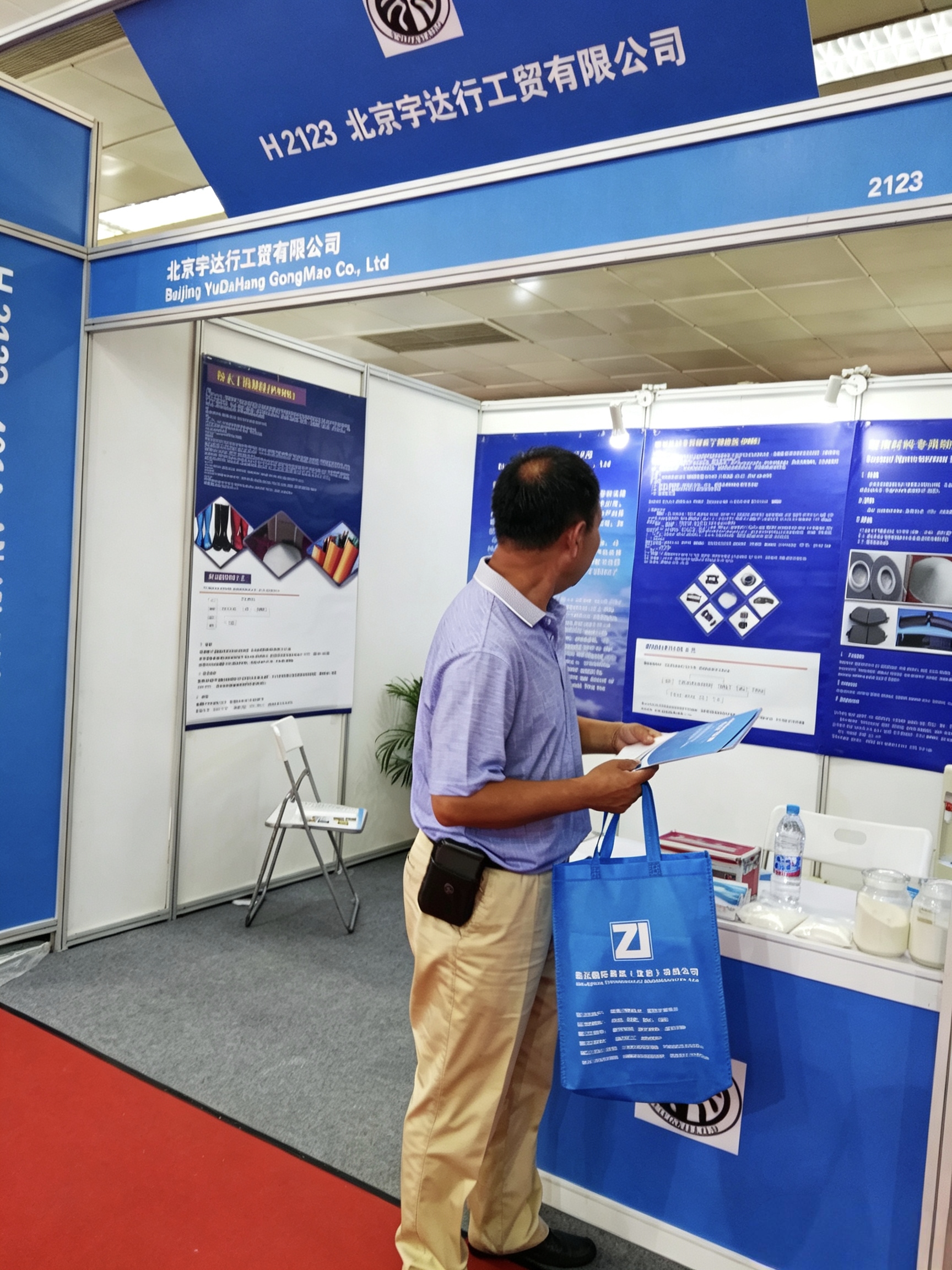 beijing-yudahang-gongmao-booth-h2123-at-rubber-plastics-exhibition-visitor-checking-brochure